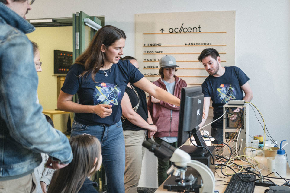 Menschen, die eine wissenschaftliche Arbeit erklärt bekommen